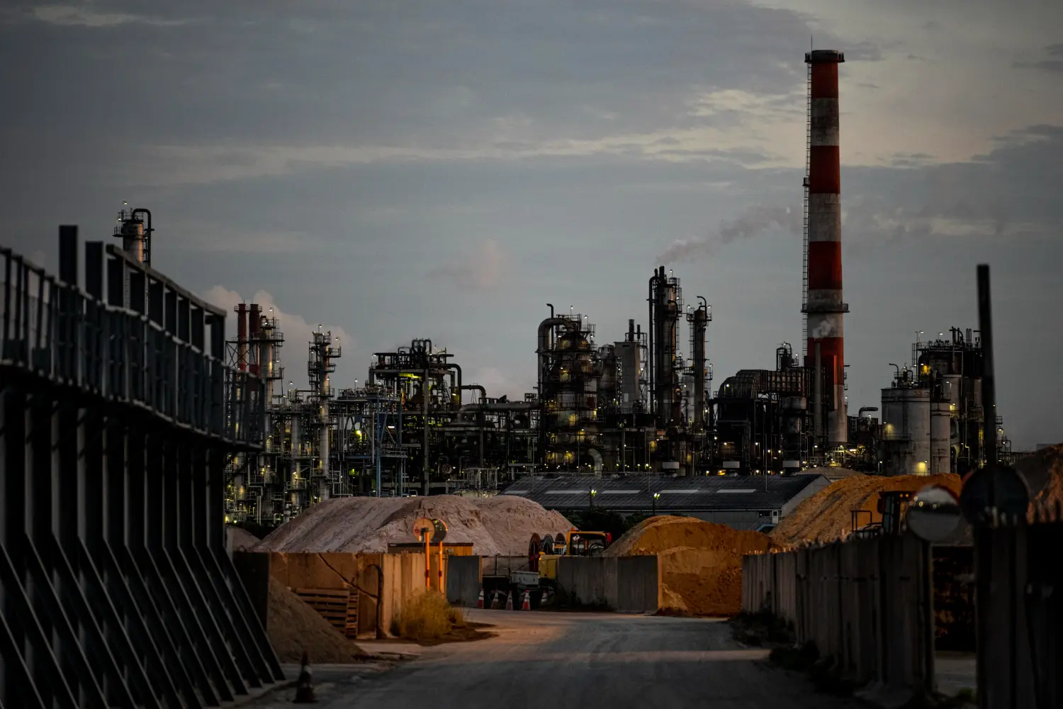 Industrial oil refinery plant at sunset with lights